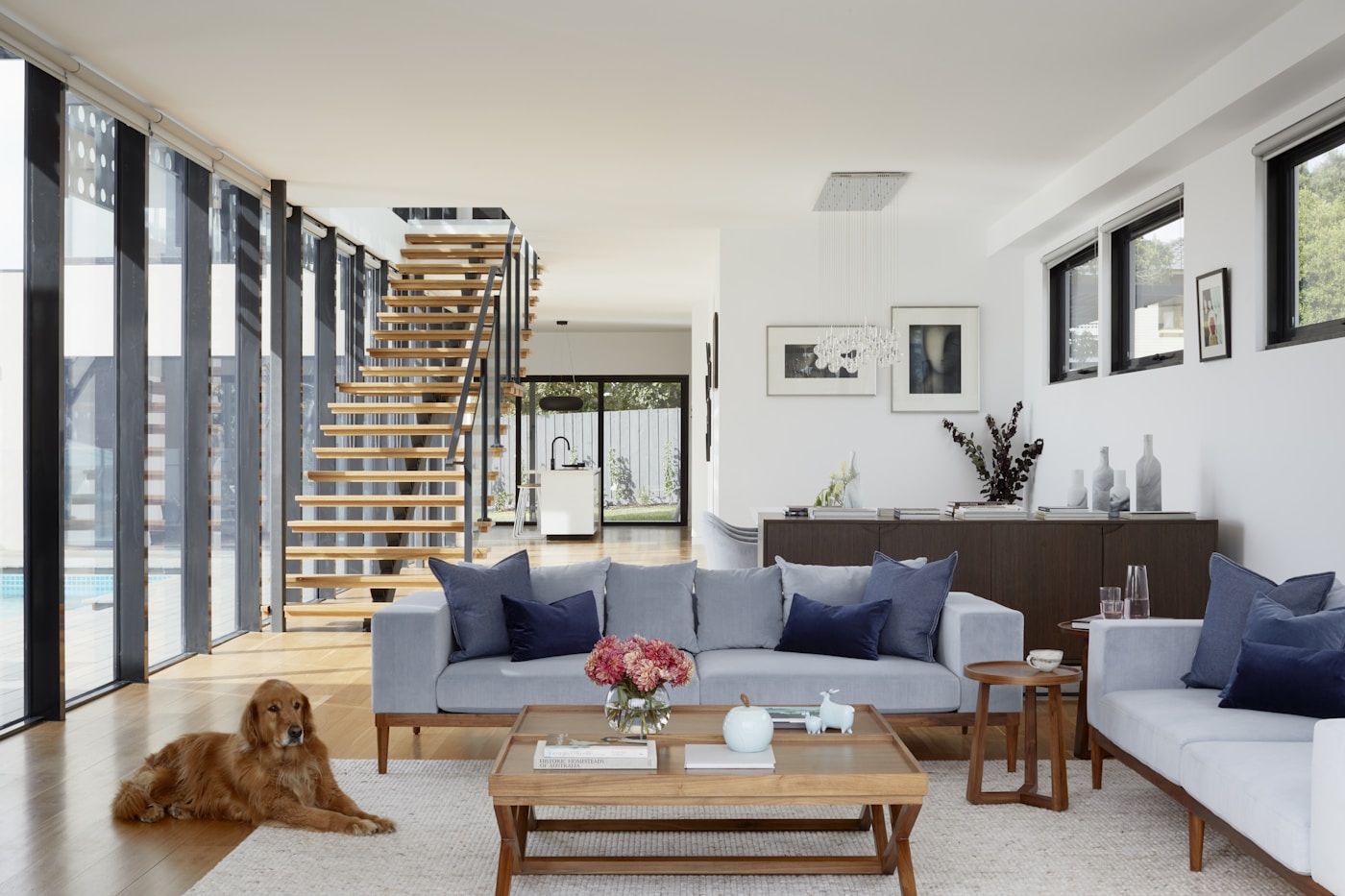 Bright renovated living space with timber staircase and full-height windows